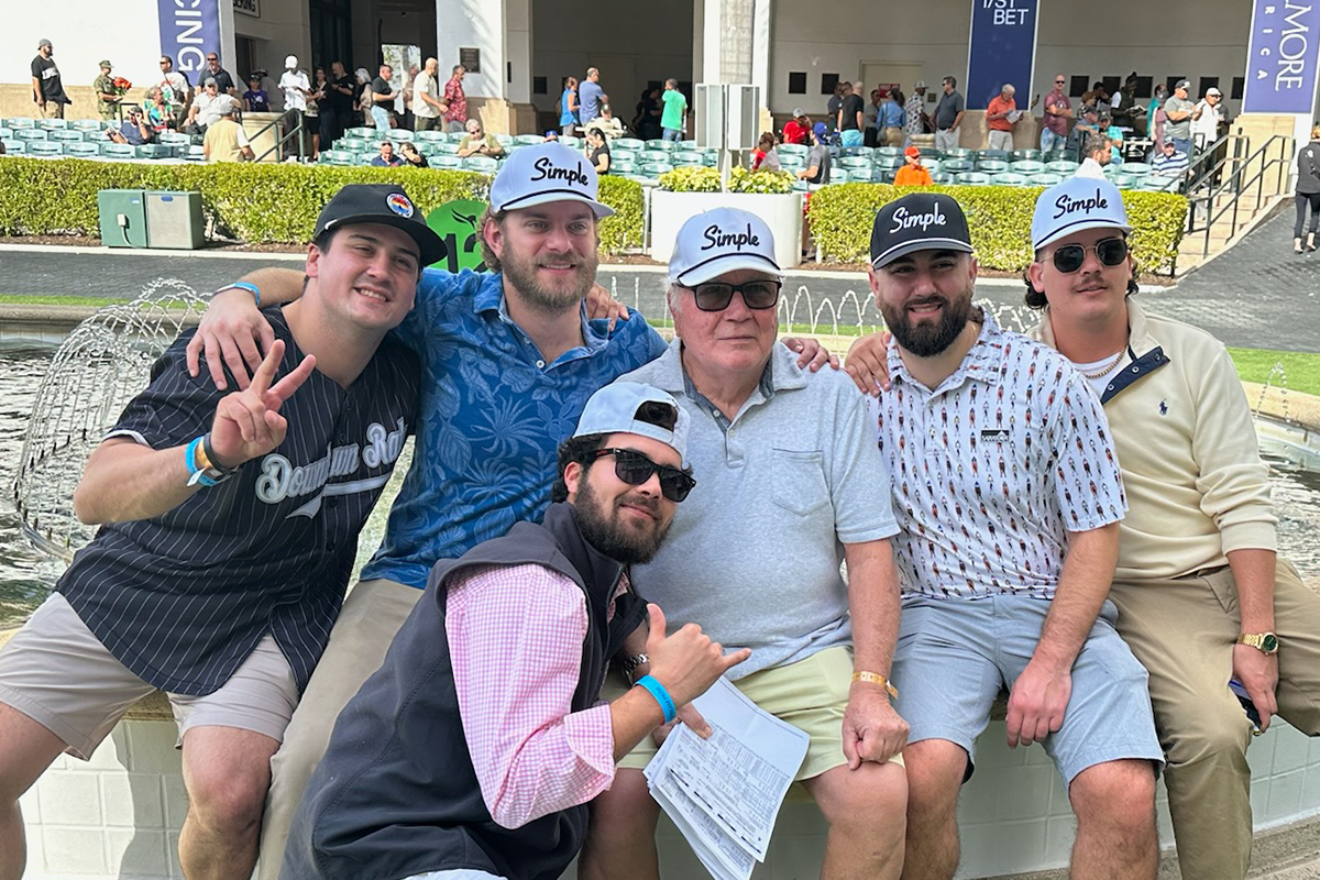 A group of friends and family enjoying time together at an outdoor event, proudly wearing 'Simple' branded hats. This moment captures the essence of our brand — spreading positivity, connection, and a laid-back vibe through simple, authentic moments with the people who matter most.